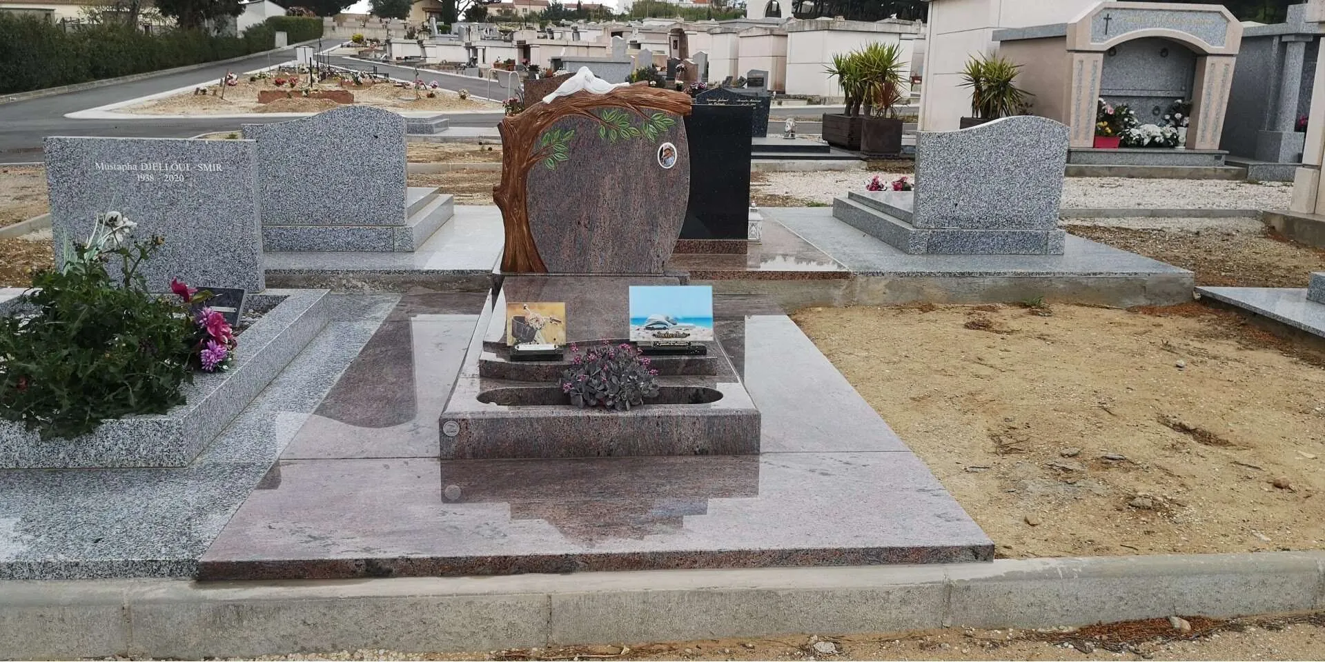 Pierre tombale double en granit gris clair installée en cimetière