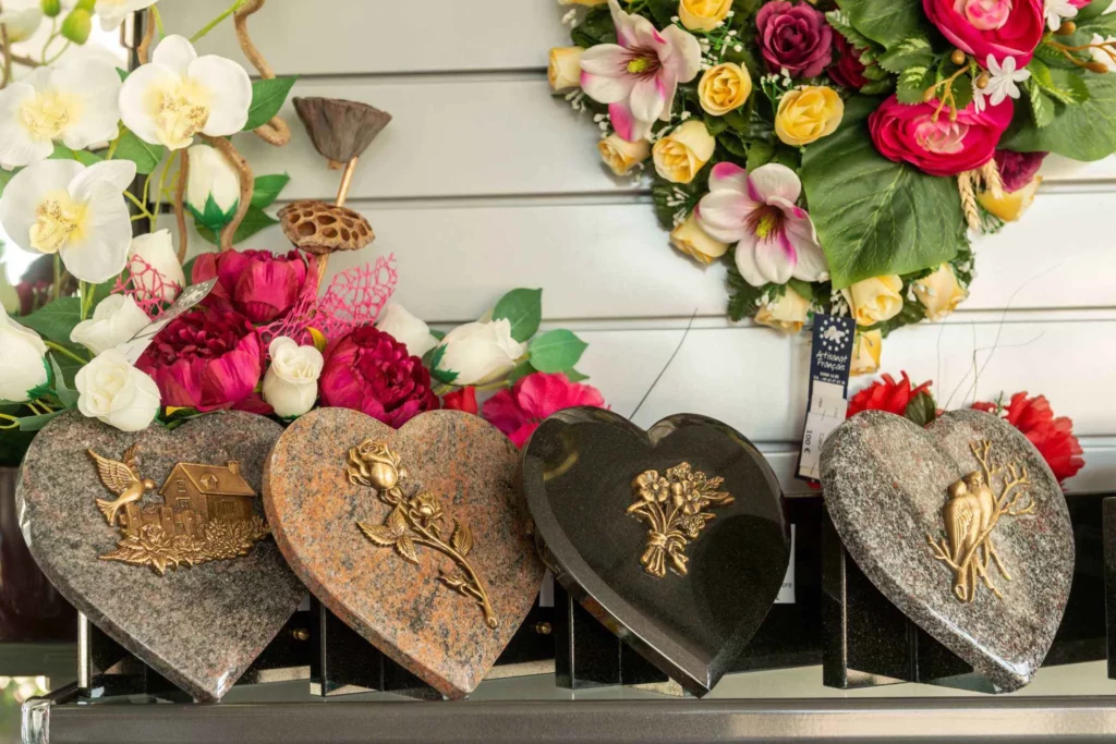 Plaques commémoratives en granit gravé et fleurs artificielles pour hommage